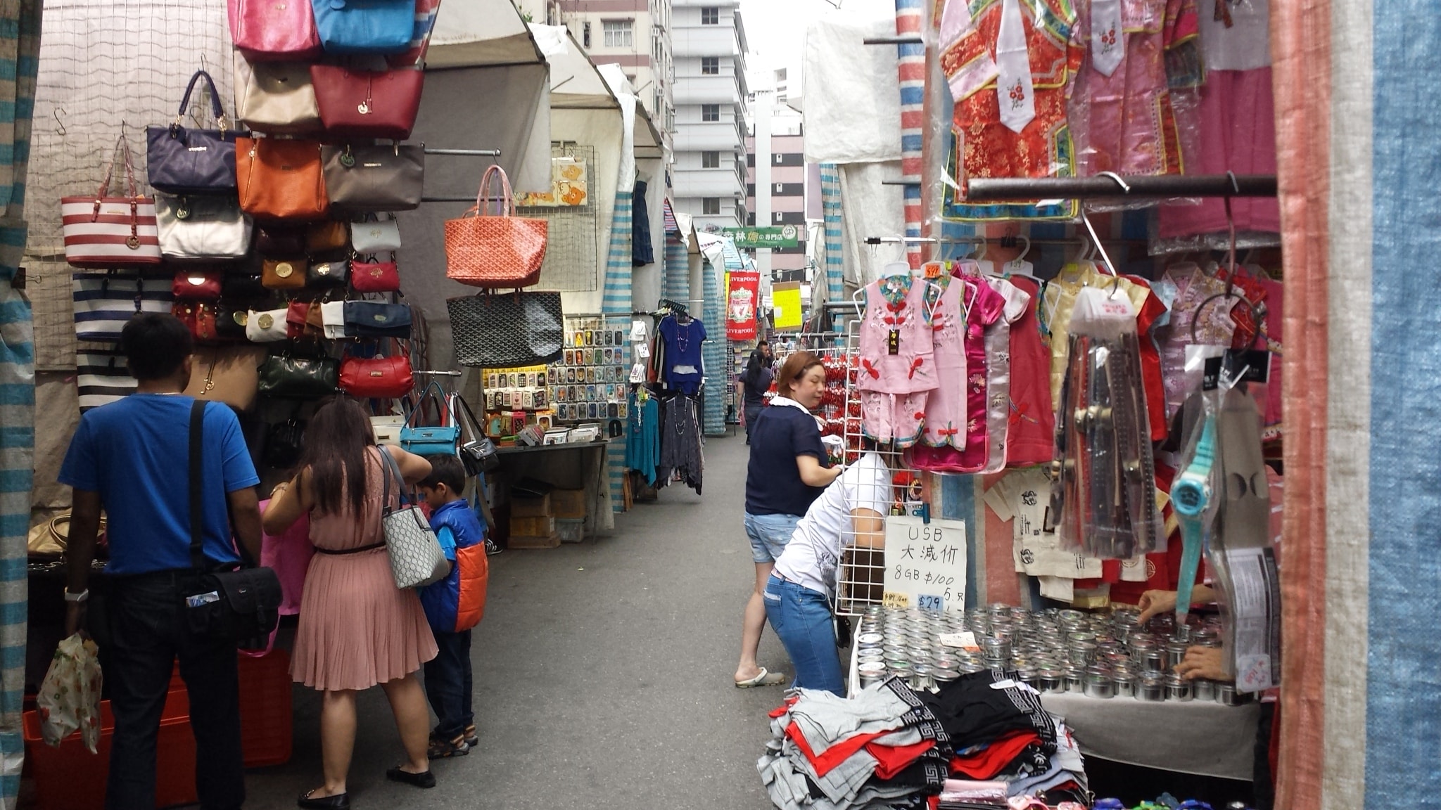 Shoppers browsing bags and clothing at the Ladies Market in Mong Kok, Hong Kong